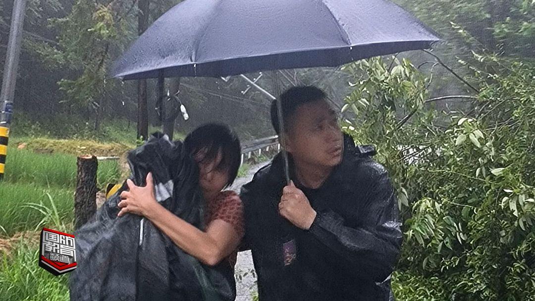新闻特写——暴雨倾盆中的温情瞬间：“雨衣，给孩子遮上”